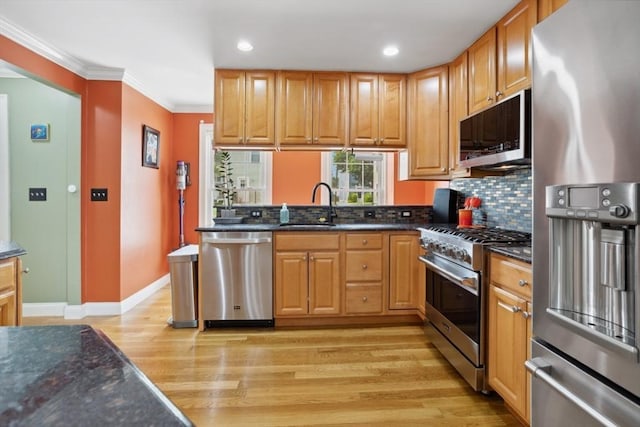 224 Grove St Unit 2, Waltham, MA 02453 - kitchen with stainless steel appliances, light wood finished floors, tasteful backsplash, crown molding, and dark stone countertops