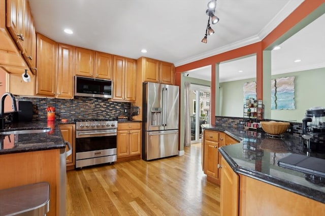 224 Grove St Unit 2, Waltham, MA 02453 - kitchen with stainless steel appliances, light wood-style floors, tasteful backsplash, dark stone counters, and ornamental molding