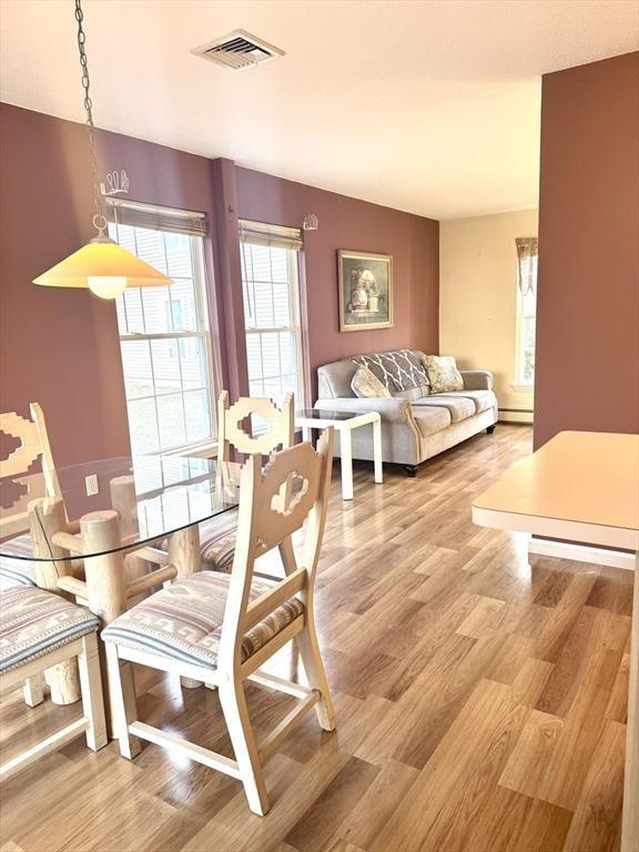 dining room featuring a baseboard radiator and light hardwood / wood-style flooring