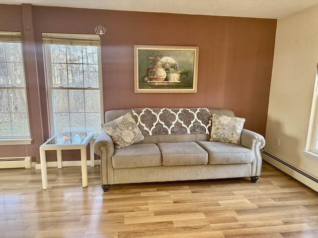 living room with a baseboard radiator and light hardwood / wood-style floors