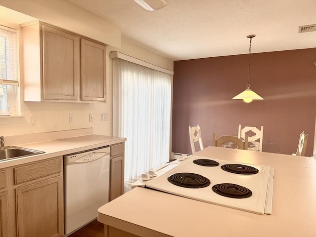 kitchen with white appliances, light brown cabinetry, sink, and hanging light fixtures