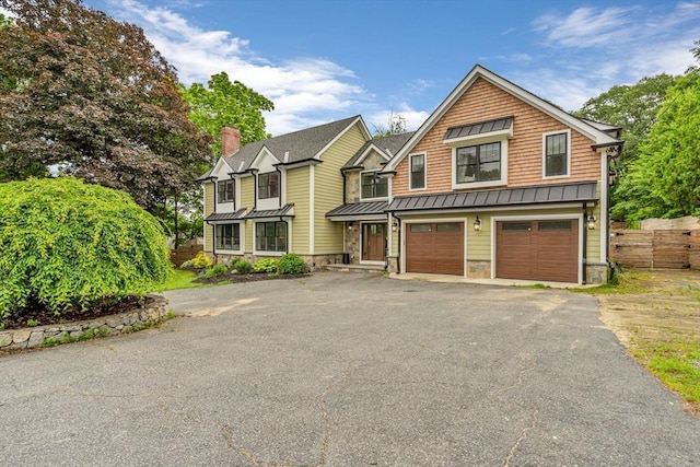 34 Cedar St, Hopkinton, MA 01748 - view of front of house featuring a standing seam roof, asphalt driveway, a garage, a metal roof, and stone siding