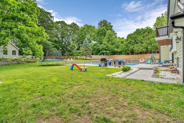 34 Cedar St, Hopkinton, MA 01748 - fenced backyard with a trampoline, a patio, and view of wooded area