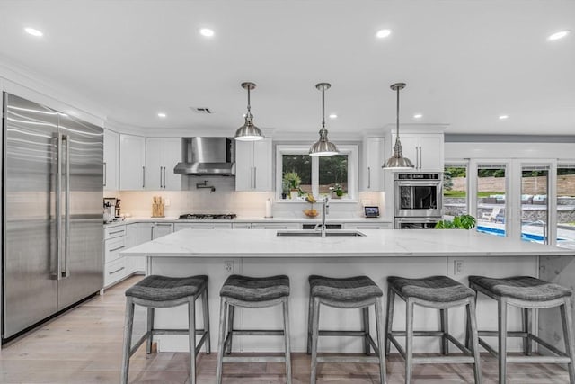 34 Cedar St, Hopkinton, MA 01748 - kitchen featuring appliances with stainless steel finishes, wall chimney exhaust hood, backsplash, white cabinets, and recessed lighting