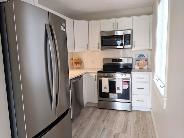 179 N End Blvd Unit A, Salisbury, MA 01952 - kitchen with stainless steel appliances, light countertops, white cabinetry, and decorative backsplash
