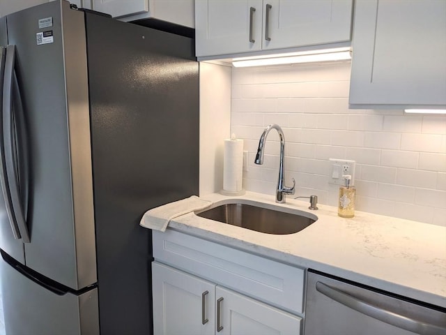 179 N End Blvd Unit A, Salisbury, MA 01952 - kitchen with stainless steel appliances, a sink, backsplash, and light stone countertops