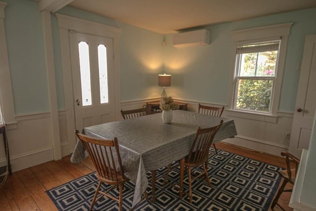 301 Main St, Dennis, MA 02639 - dining room featuring a wall mounted air conditioner, hardwood / wood-style floors, and wainscoting