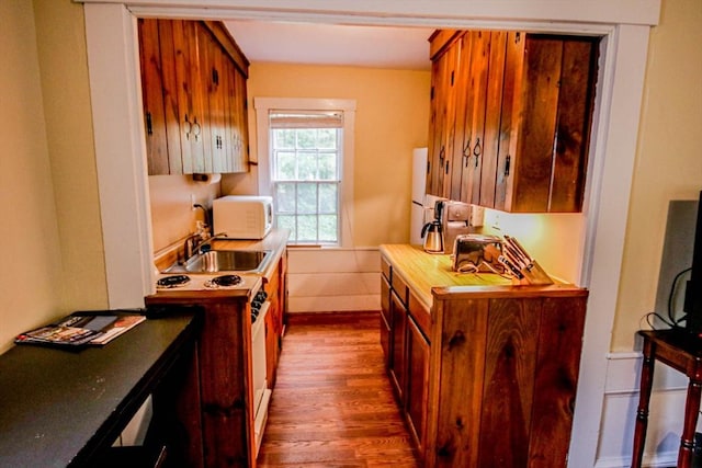 301 Main St, Dennis, MA 02639 - kitchen featuring white appliances, dark wood-style flooring, a sink, brown cabinetry, and baseboards