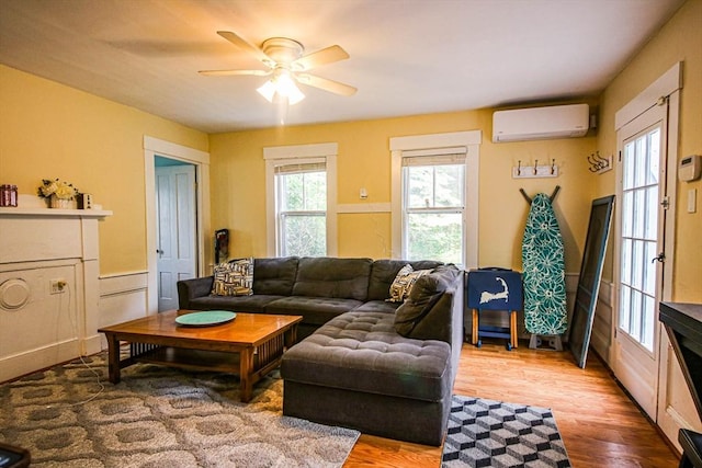 301 Main St, Dennis, MA 02639 - living room featuring a wall unit AC, a ceiling fan, and light wood-type flooring