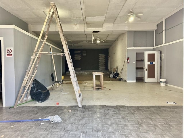 misc room with baseboards and ceiling fan