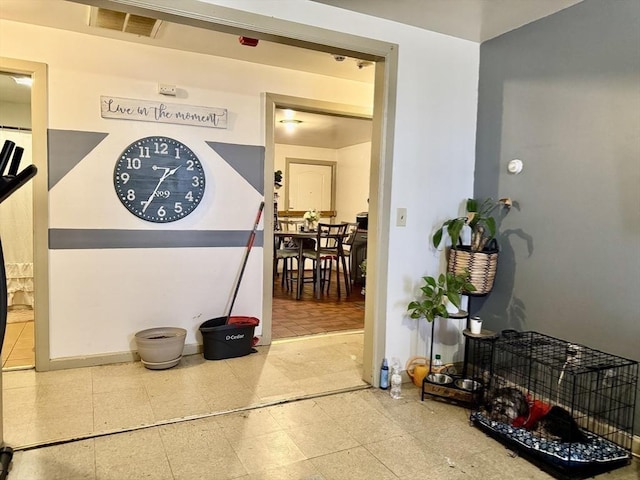 corridor featuring tile patterned floors, baseboards, and visible vents