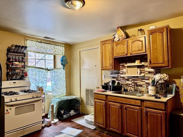 kitchen featuring a sink, light countertops, visible vents, and white gas range oven