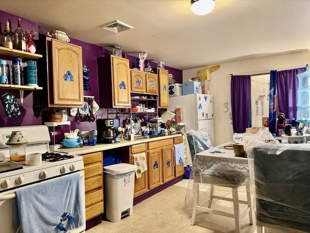 kitchen with white appliances, light countertops, visible vents, and light floors