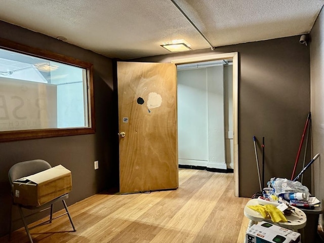 interior space featuring light wood-type flooring and a textured ceiling