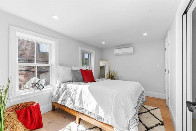 bedroom featuring light wood-type flooring and a wall mounted AC