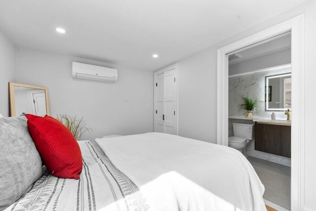 bedroom featuring ensuite bathroom, an AC wall unit, and carpet flooring