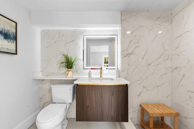 bathroom featuring tile walls, toilet, vanity, and tile patterned flooring