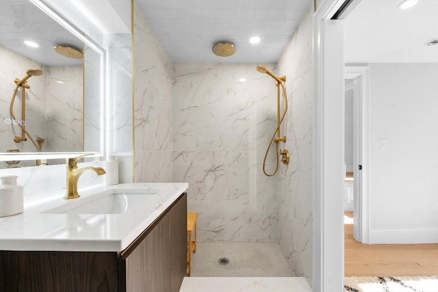 bathroom featuring vanity, tiled shower, and hardwood / wood-style flooring