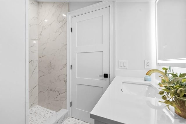 bathroom featuring tiled shower and vanity