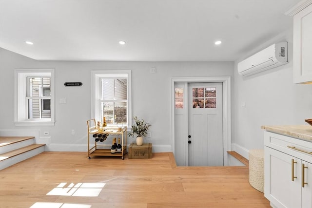 foyer featuring a wall mounted AC and light hardwood / wood-style floors