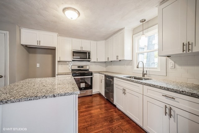 kitchen featuring white cabinetry, sink, pendant lighting, and appliances with stainless steel finishes