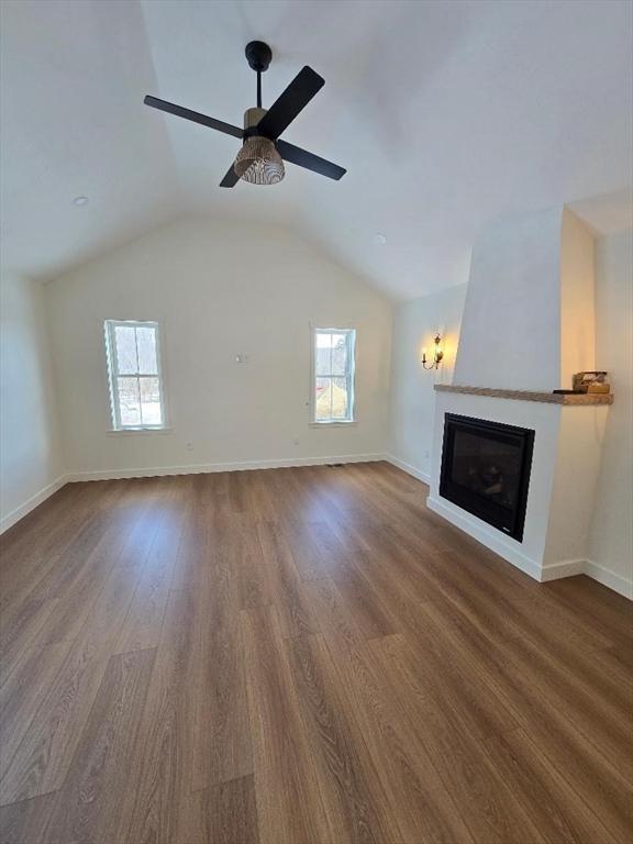 unfurnished living room featuring lofted ceiling, hardwood / wood-style flooring, and plenty of natural light