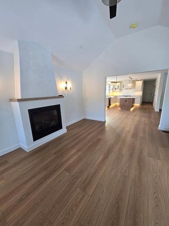 unfurnished living room featuring dark wood-type flooring and lofted ceiling