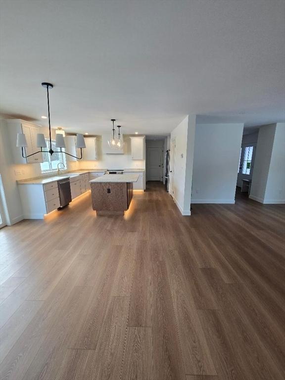 kitchen with wood-type flooring, decorative light fixtures, a chandelier, a center island, and dishwasher