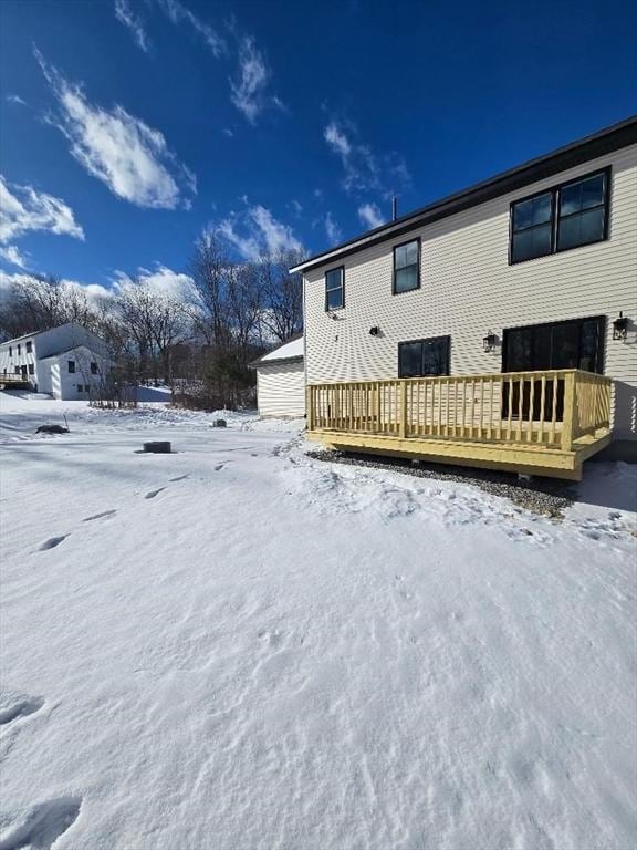 snow covered property with a deck