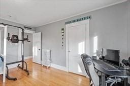 home office with ornamental molding, wood-type flooring, and radiator