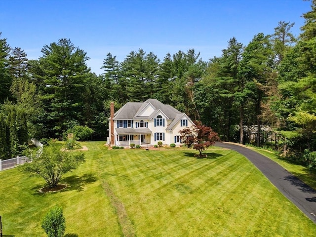 453 Forest St, North Andover, MA 01845 - view of front of house featuring a chimney, a view of trees, and covered porch