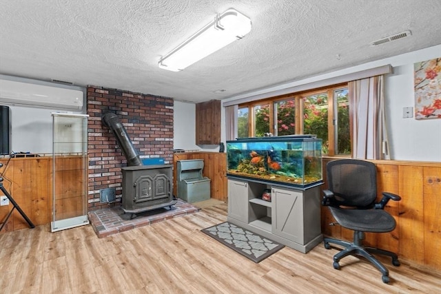 46 Lisa Ln, Methuen, MA 01844 - home office featuring a textured ceiling, wood finished floors, a wood stove, a wall mounted AC, and wood walls