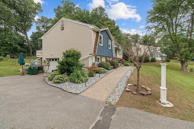 46 Lisa Ln, Methuen, MA 01844 - view of home's exterior featuring driveway, an attached garage, and a lawn