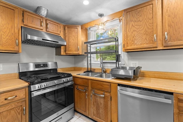 46 Lisa Ln, Methuen, MA 01844 - kitchen featuring appliances with stainless steel finishes, under cabinet range hood, light countertops, and brown cabinets