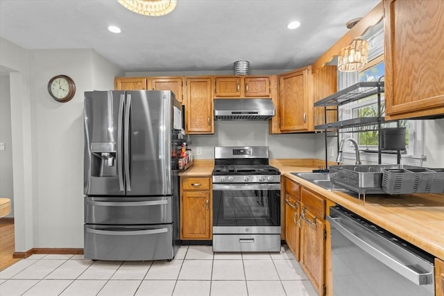 46 Lisa Ln, Methuen, MA 01844 - kitchen featuring stainless steel appliances, ventilation hood, light countertops, recessed lighting, and brown cabinetry