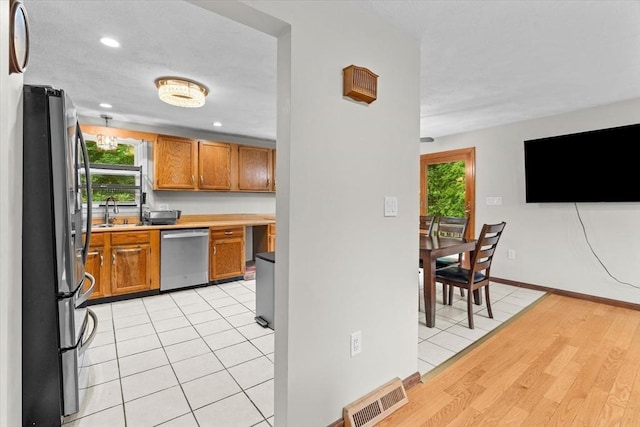 46 Lisa Ln, Methuen, MA 01844 - kitchen featuring stainless steel appliances, brown cabinets, light wood finished floors, light countertops, and recessed lighting