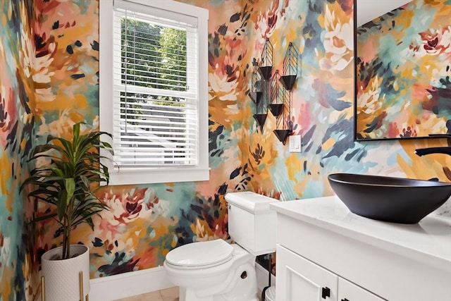 38 Thatcher St, Medford, MA 02155 - bathroom with wallpapered walls, baseboards, toilet, vanity, and tile patterned flooring