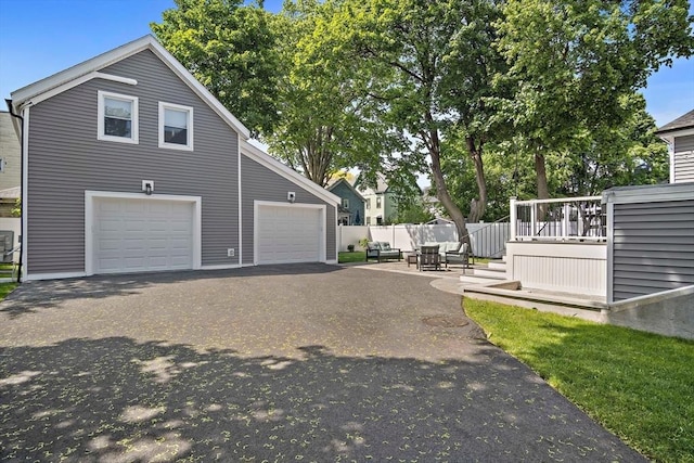 38 Thatcher St, Medford, MA 02155 - view of home's exterior featuring fence, a garage, a wooden deck, and asphalt driveway