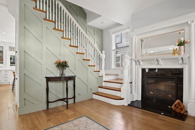 38 Thatcher St, Medford, MA 02155 - staircase featuring wood finished floors and a glass covered fireplace
