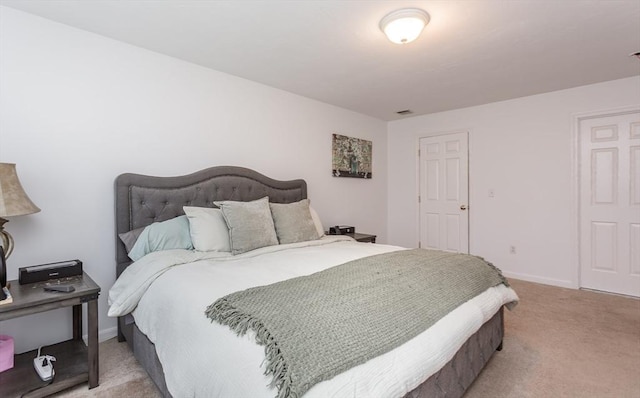 bedroom with baseboards and light carpet