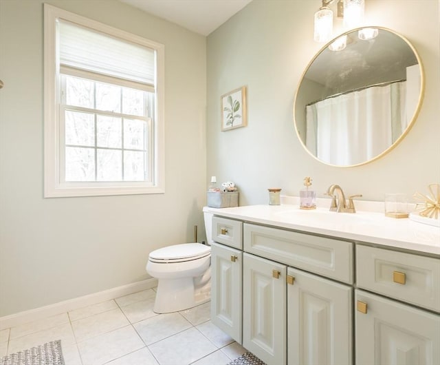 bathroom with vanity, toilet, tile patterned flooring, and baseboards