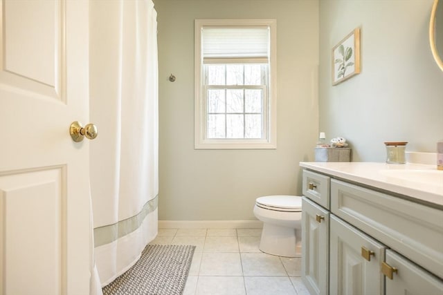 bathroom featuring tile patterned flooring, toilet, vanity, baseboards, and a shower with shower curtain