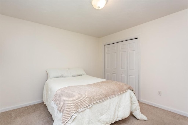 bedroom featuring baseboards, carpet floors, and a closet