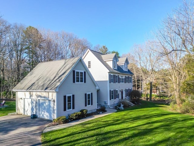 view of front of home featuring an attached garage, a front yard, and aphalt driveway