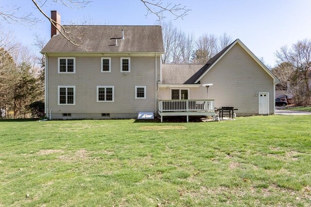 back of house with a chimney, a yard, a shingled roof, and a deck