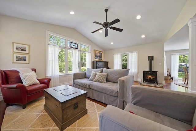 living area featuring vaulted ceiling, a ceiling fan, light wood-type flooring, a wood stove, and recessed lighting