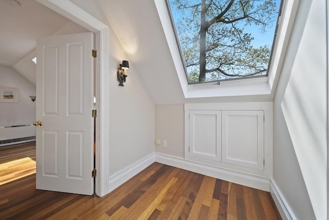 bonus room with lofted ceiling, dark wood-style flooring, baseboards, and a skylight
