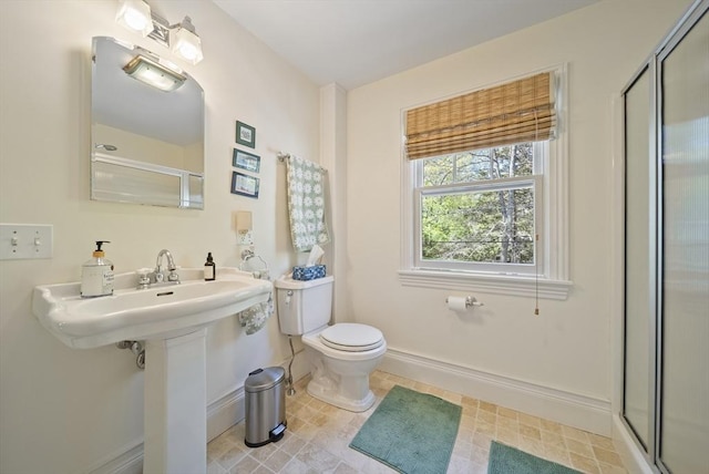 full bathroom featuring baseboards, a stall shower, and toilet