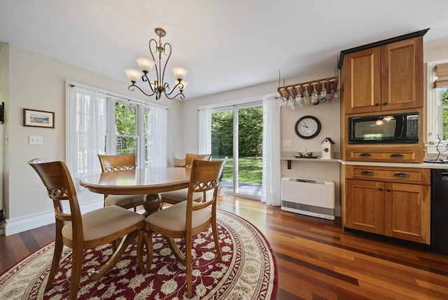 dining room featuring heating unit, dark wood-type flooring, a chandelier, and baseboards