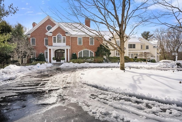 view of front of house featuring a chimney and brick siding